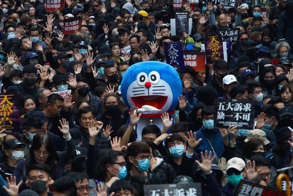 Hong Kong people participate in their annual pro-democracy march on New Year's Day to insist their five demands be matched by the government in Hong Kong, Wednesday, Jan. 1, 2020. The five demands include democratic elections for Hong Kong's leader and legislature and a demand for a probe of police behavior during the six months of continuous protests. (AP Photo/Vincent Yu)