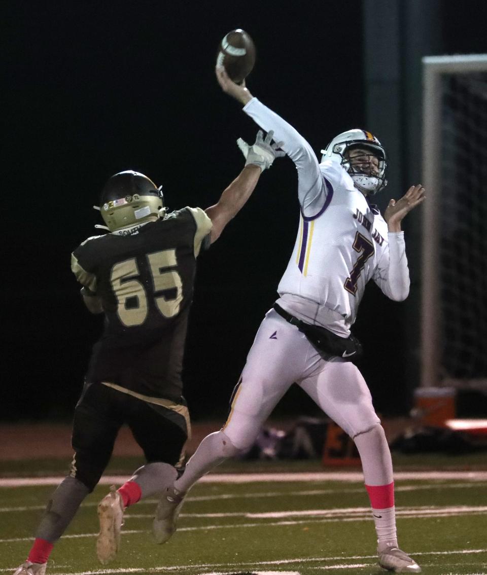John Jay-Cross River's Craig Galea throws for a touchdown under pressure from Clarkstown South's Federico Feteira during their Section 1 Class A quarterfinal at Clarkstown South Oct. 28, 2022. John Jay won 55-28.