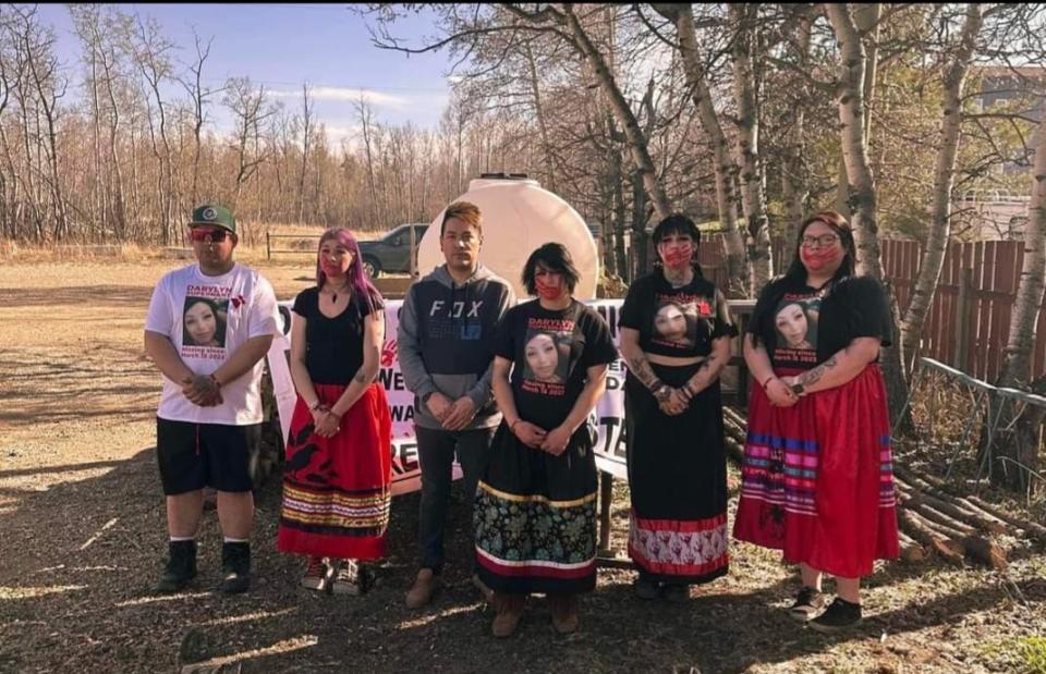 Siblings of Darylyn Supernant wear shirts with her photo and a face paint of a red hand across their mouths, symbolizing missing and murdered Indigenous women in Canada and the United States.