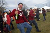 Harvard University football fans spray champagne during a pre-game tailgate-style party outside the stadium before their football game against Yale University at Harvard in Cambridge, Massachusetts November 22, 2014. Known as "The Game," the first Harvard versus Yale football game was played in 1875, making it one of the oldest rivalries in college sports. REUTERS/Brian Snyder (UNITED STATES - Tags: EDUCATION SPORT FOOTBALL)