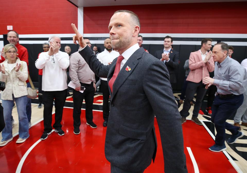 Louisville basketball coach Pat Kelsey gives the “L’s” up sign as he arrives for his introductory news conference in late March.