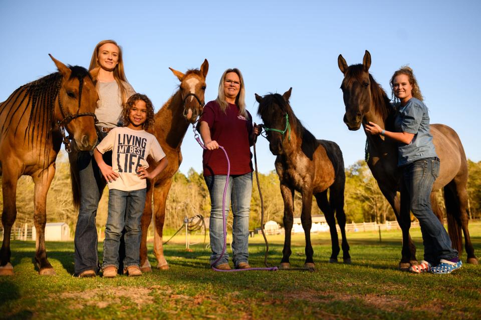 Laikyn Hawk, Kash Griffin, Tammy Coppage and Molly Simpson pose with their Marsh Tacky horses Estelita, Blue Jeans, Cricket and Sprite on March 29, 2021. The Marsh Tacky is believed to be a descendant of Spanish horses that evolved to have unique adaptations to the marshy low country conditions.