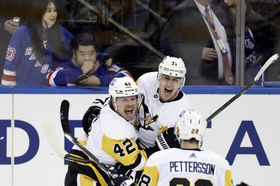 Pittsburgh Penguins center Evgeni Malkin (71) celebrates with teammates after scoring against the New York Rangers during the third overtime in Game 1 of an NHL hockey Stanley Cup first-round playoff series, Tuesday, May 3, 2022, in New York. The Penguins won 4-3. (AP Photo/Adam Hunger)