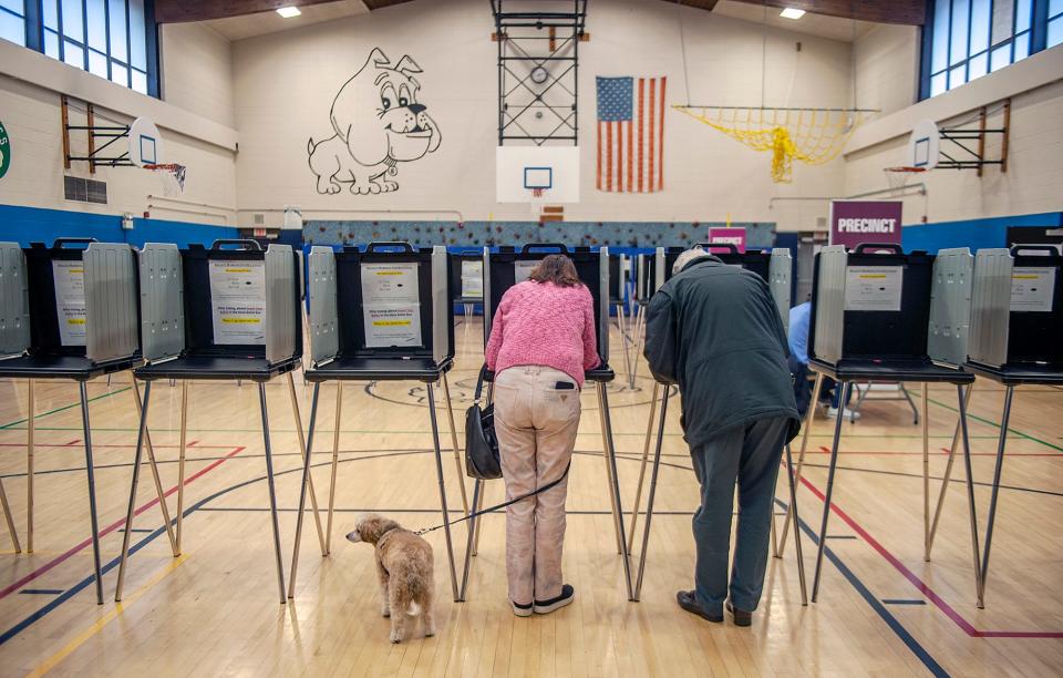 Joined by their dog, Parker, Marie and Larry O'Rourke cast their votes in Framingham, Massachusetts, on Super Tuesday.