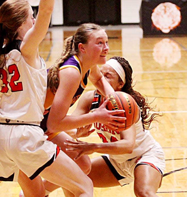 Watertown's Emery Thury fights through the defense by Huron's Karsyn Kopfmann (32) and Heaven Gainey during a high school girls basketball on Thursday, Feb. 16, 2023 in the Huron Arena.