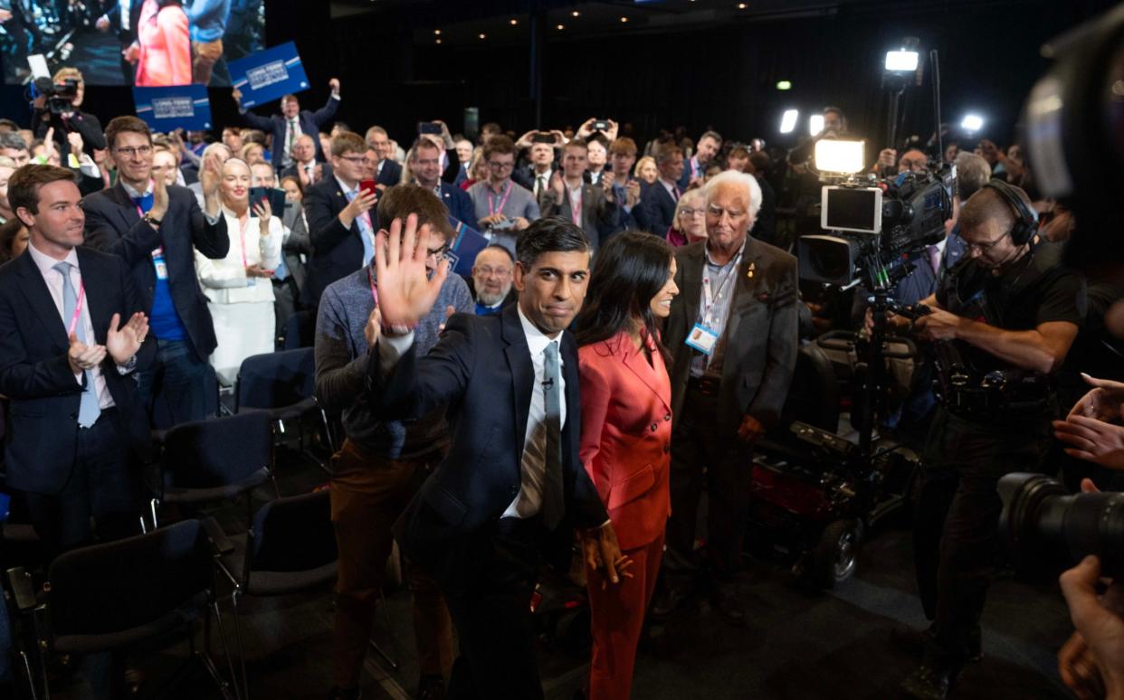 Rishi Sunak and his wife Akshata Murty leaving a crowded room