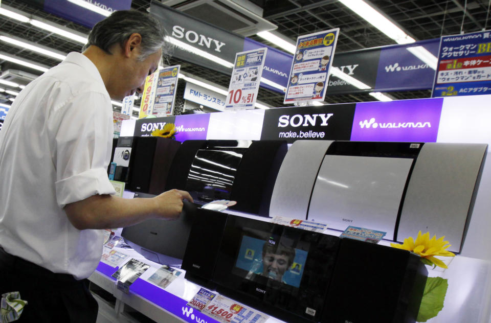 A shopper tries a Sony's product at a store in Tokyo, Thursday, Aug. 2, 2012. Sony is reporting a bigger loss for the April-June quarter at 24.6 billion yen ($316 million) despite a sales recovery from a disaster-struck previous year. (AP Photo/Koji Sasahara)