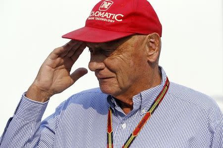 Austrian Formula One legend Niki Lauda salutes as he walks in the paddock ahead of the Singapore F1 Grand Prix at the Marina Bay street circuit in Singapore September 21, 2014. REUTERS/Xavier Galiana