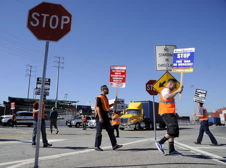 Striking trucker drivers and members of the International Brotherhood of Teamsters walk the picket line at the Port of Long Beach in California, United States April 27, 2015. REUTERS/Bob Riha Jr.