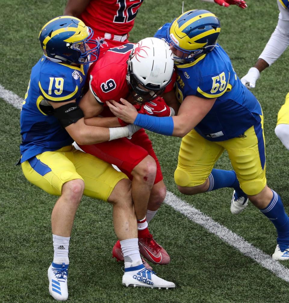 Delaware's Matt Palmer (left) and Jake Reed converge on Richmond punt returner Charlie Fessler in the second quarter at Delaware Stadium Saturday.