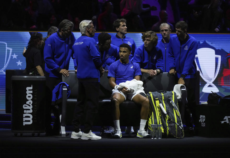 Team Europe's Arthur Fils, front center, sits on the sideline as coach Bjorn Borg, front left, and teammates surround him after losing the first set to Team World's Ben Shelton during a Laver Cup tennis singles match in Vancouver, British Columbia, Friday, Sept. 22, 2023. (Darryl Dyck/The Canadian Press via AP)