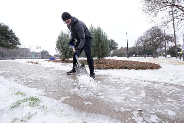 Joshua Lang shovels ice off a public walkway leading into a neighborhood park near his home, Wednesday, Feb. 1, 2023, in Dallas. (AP Photo/Tony Gutierrez)