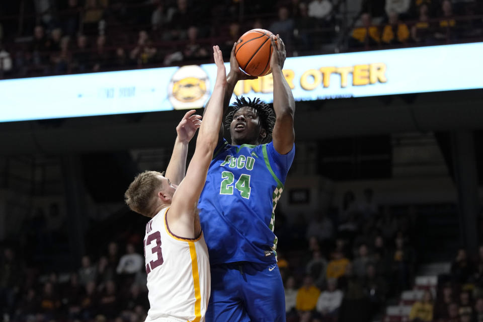 Florida Gulf Coast forward Josiah Shackleford (24) goes up for a shot as Florida Gulf Coast guard Dallion Johnson (23) defends during the second half of an NCAA college basketball game Saturday, Dec. 9, 2023, in Minneapolis. (AP Photo/Abbie Parr)