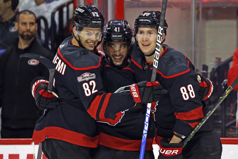Carolina Hurricanes' Shayne Gostisbehere celebrates his goal with teammates Jesperi Kotkaniemi (82) and Martin Necas (88) during the second period of an NHL hockey game against the Tampa Bay Lightning in Raleigh, N.C., Sunday, March 5, 2023. (AP Photo/Karl B DeBlaker)