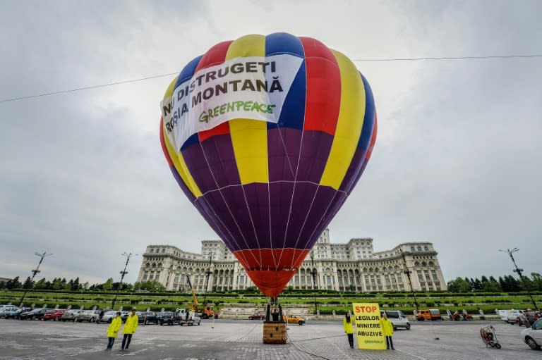 Activists stand next to a hot air balloon with a banner reading "Do not destroy Rosia Montana", to protest against the Rosia Montana Gold Corporation on June 5, 2014 in Bucharest, Romania