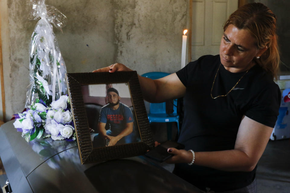 Elsi Meléndez mira una foto de su pariente Edin Umaña en su velorio en Protección, Honduras, el miércoles 12 de abril de 2023. Umaña fue uno de los migrantes que murió en un incendio en un centro de detención de migrantes en México en Ciudad Juárez, el pasado 27 de marzo. (AP Foto/Delmer Martínez)