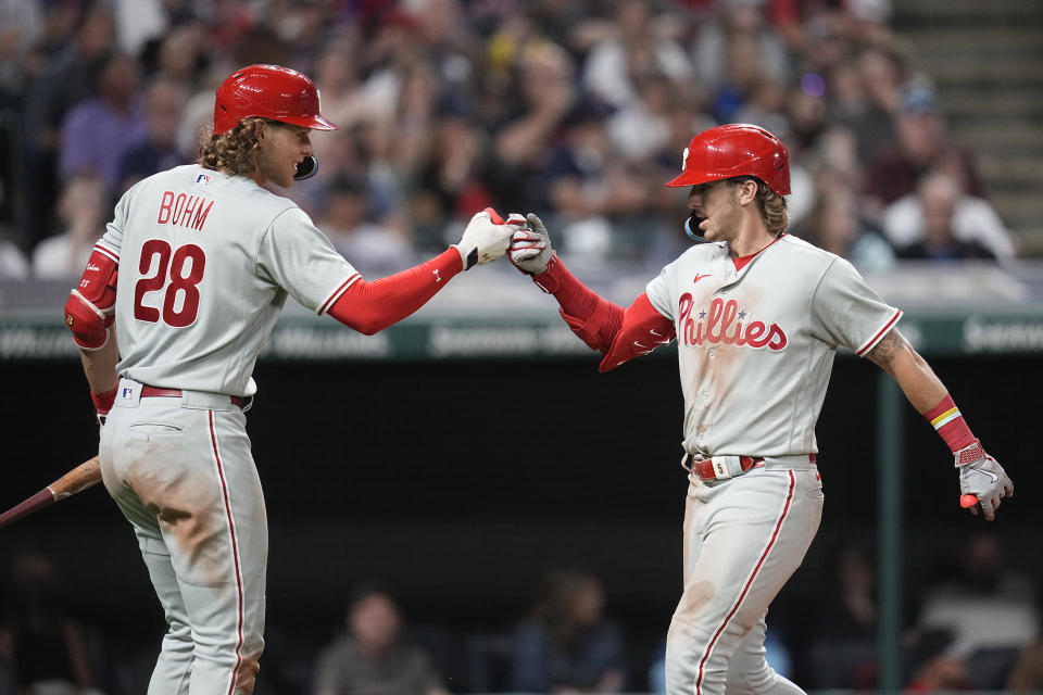 Philadelphia Phillies' Alec Bohm (28) and Bryson Stott, right, celebrate after Stott's home run in the seventh inning of a baseball game against the Cleveland Guardians, Friday, July 21, 2023, in Cleveland. (AP Photo/Sue Ogrocki)