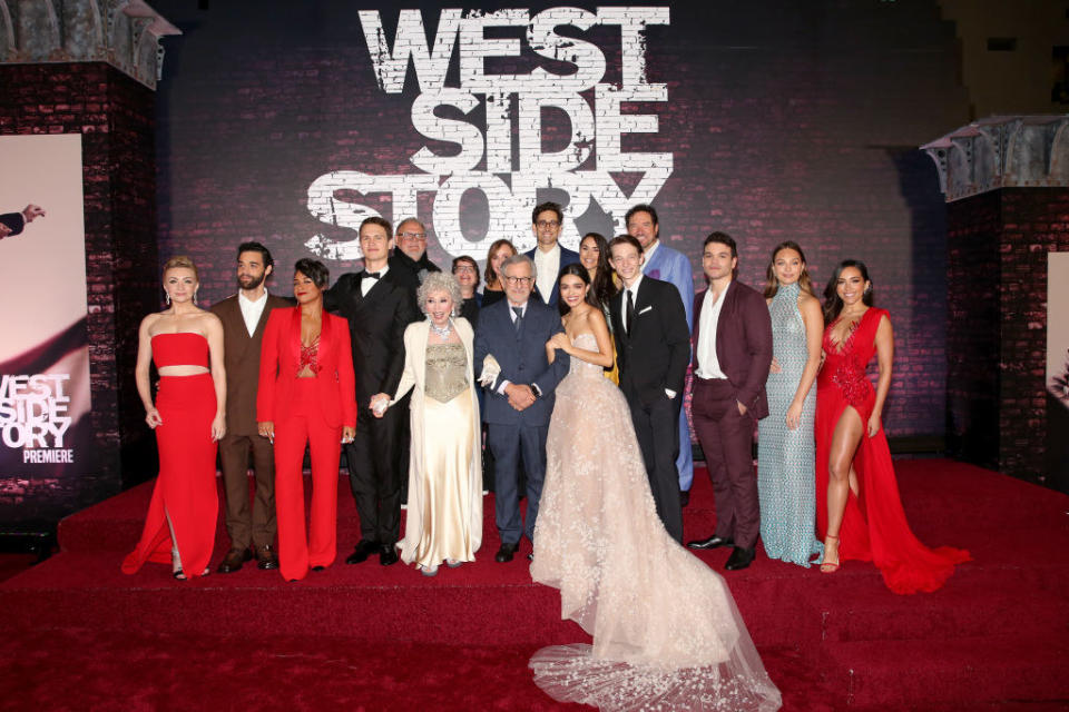 The cast of "West Side Story" featuring Ariana DeBose, Ansel Elgort, Rita Moreno, Steven Spielberg, Rachel Zegler, Maddie Ziegler, and others posing for a photo