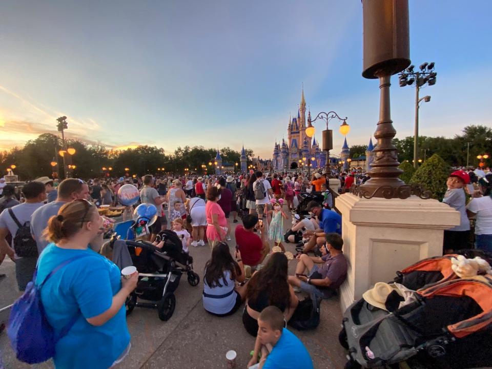 People hold their spots to watch the nightly fireworks at Magic Kingdom in August 2021.