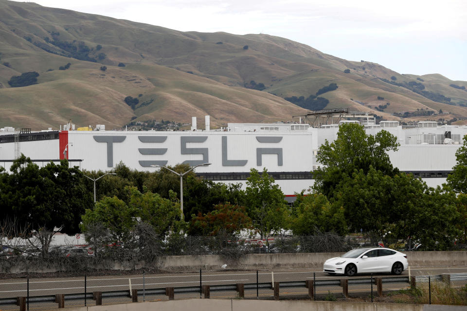 FILE PHOTO: A Tesla vehicle drives past Tesla's primary vehicle factory in Fremont, California, U.S. May 11, 2020. REUTERS/Stephen Lam/File Photo