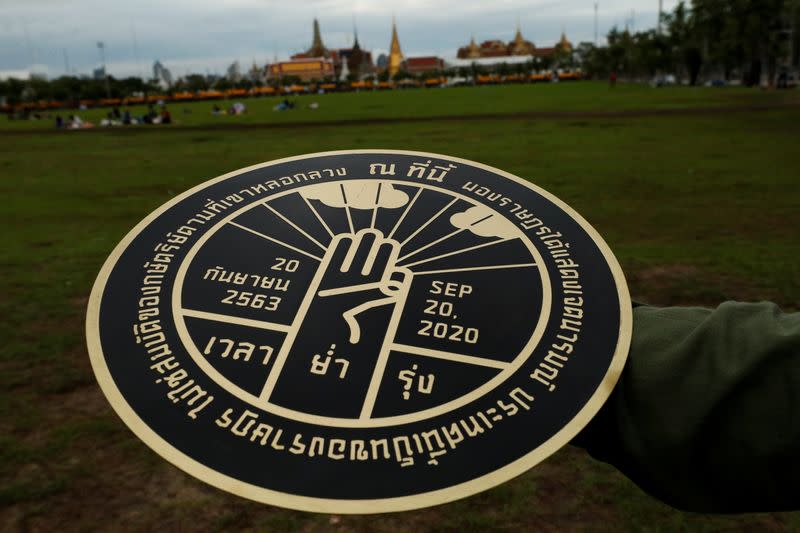 A student holds a replica of the plaque installed by students leaders near the Grand Palace, in Bangkok