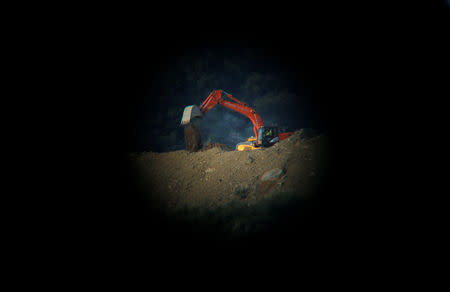 A digger pours sand next to the area where Julen, a Spanish two-year-old boy who fell into a 25-centimetre (9.8 inch) wide and around 100-metre (328 feet) deep well four days ago when the family was taking a stroll through a private estate, in Totalan, southern Spain, January 17, 2019. REUTERS/Jon Nazca