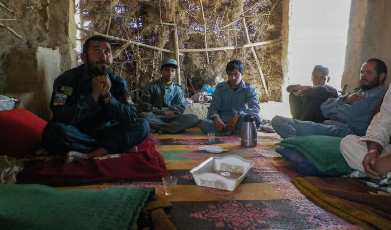 Afghan police commander Seddiqullah, 30, (L) sits with his subordinates as he speaks to AFP about the use of child sex slaves by the Taliban to attack police in Tarin Kot, Uruzgan