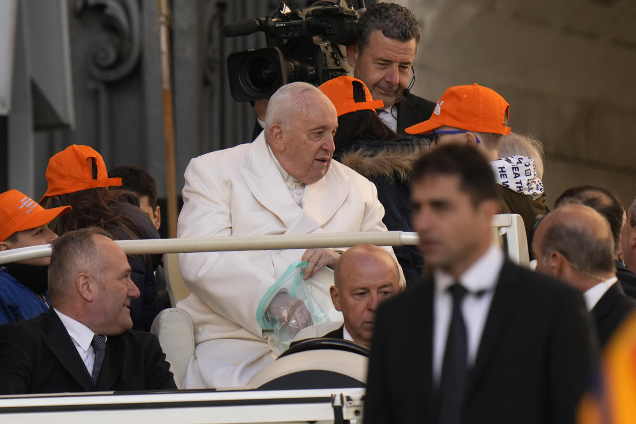 Pope Francis holds a plastic bag as he arrives for his weekly general audience in St. Peter's Square, at the Vatican, Wednesday, March 29, 2023. (AP Photo/Alessandra Tarantino)