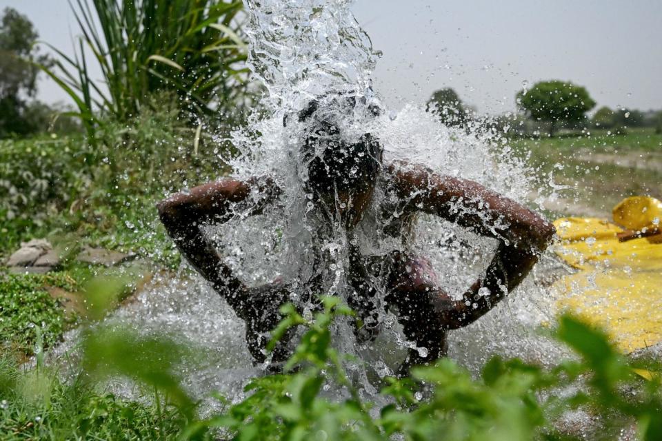 PHOTO: A man takes a shower under water pouring from a pipe along the Yamuna flood plains on a hot summer afternoon in New Delhi on May 29, 2024, amid ongoing heatwave. (Arun Sankar/AFP via Getty Images)