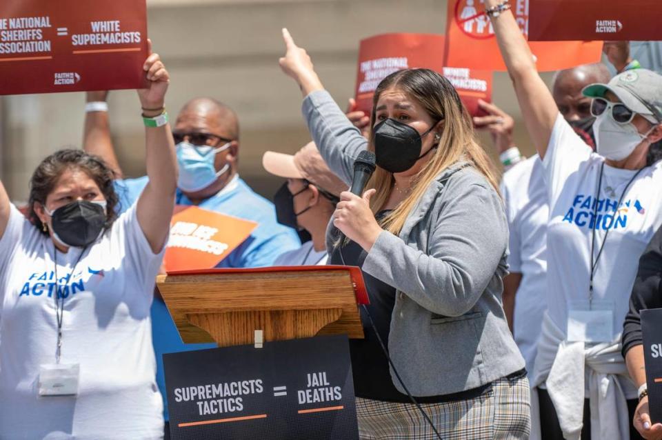 Faith in Action spokesperson, Yaquelin Valencia, speaks at a gathering in Kansas City on Monday to protest white supremacy in law enforcement as the National Sheriffs’ Association held its annual conference downtown. Clergy and community members spoke outside Grace and Holy Trinity Cathedral, across the street from the convention.