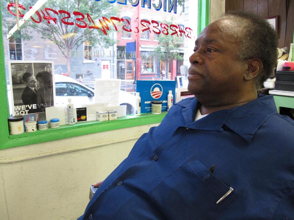 In this Wednesday, Aug. 22, 2012 photo, Carlton Nicholson sits in his empty barber shop in downtown Raleigh, N.C. The black vote helped Barack Obama become the first Democrat in a generation to take the state, but Nicholson worries the bad economy will cost him this time around. (AP Photo/Allen Breed)