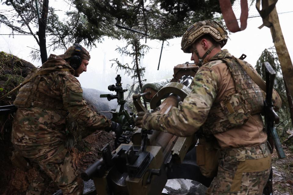 Ukrainian paratroopers load ammunition into L119 howitzer and aim to fire at Russian positions at a frontline in the Lugansk region (AFP via Getty Images)