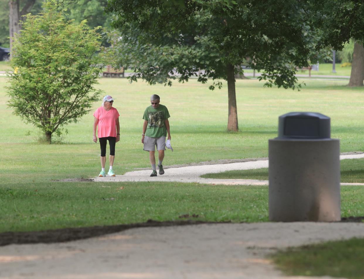 Judy and Jim Gillick make their way along the new Schneider Park walking path Monday in West Akron. "It's really nice to not have to walk in the street," said Judy. "It's fabulous."