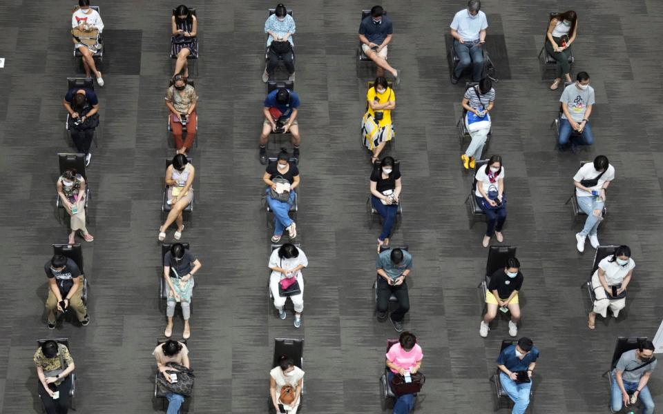 People wait for the the AstraZeneca Covid-19 vaccination at Paragon shopping mall in Bangkok, Thailand - Sakchai Lalit/AP