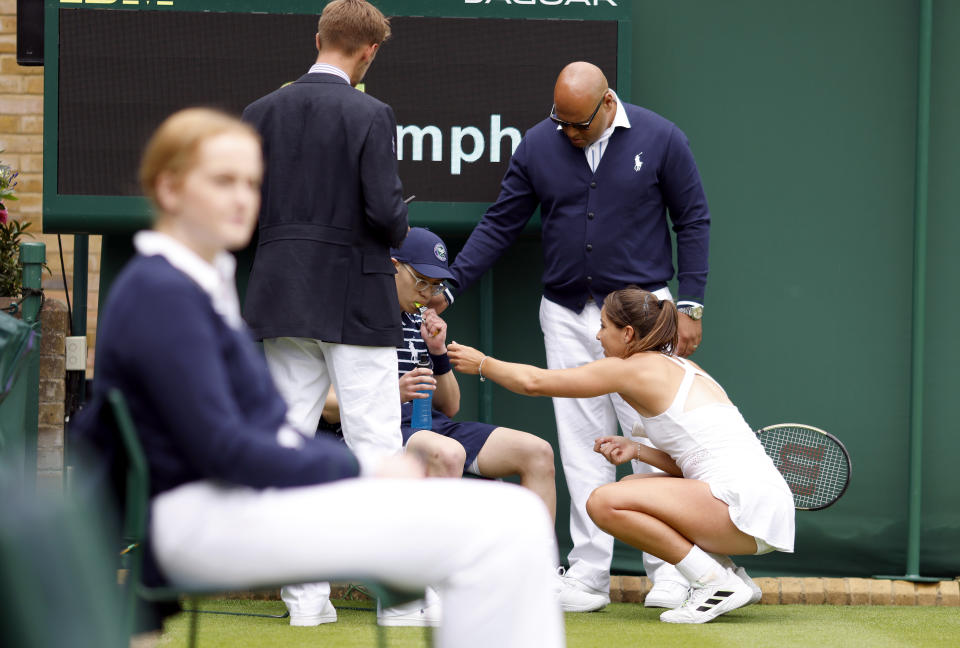 Jodie Burrage helps a ball boy at Wimbledon