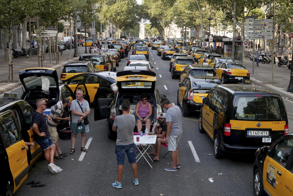 Taxi drivers block the Gran Via avenue in Barcelona, Spain, Monday, July 30, 2018. Taxi drivers in Barcelona are blocking traffic on a major thoroughfare as part of an indefinite strike to protest the use of ride-hailing apps like Uber and Cabify. (AP Photo/Manu Fernandez)