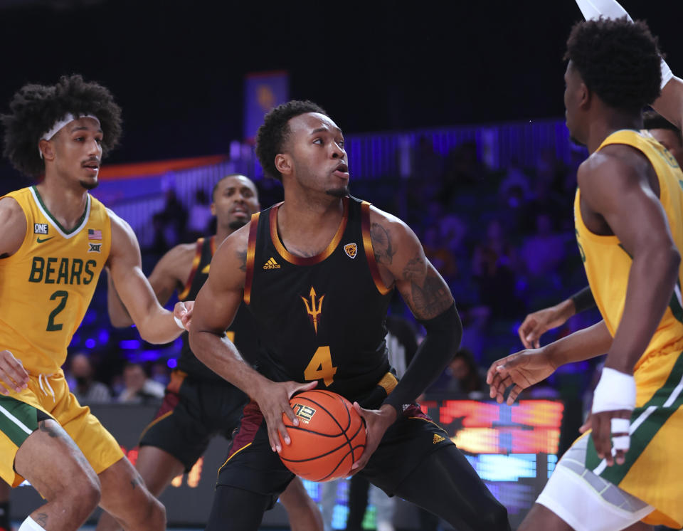 In a photo provided by Bahamas Visual Services, Arizona State forward Kimani Lawrence (4) looks for a shot against Baylor players, including Kendall Brown (2), during an NCAA college basketball game at Paradise Island, Bahamas, Wednesday, Nov. 24, 2021. (Tim Aylen/Bahamas Visual Services via AP)