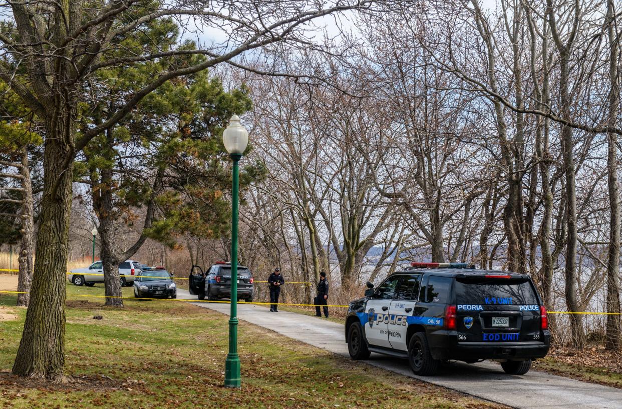 Peoria police officers investigate the area where a body was discovered Tuesday, March 21, 2023 in the Illinois River along the trail just north of the RiverPlex in Peoria.