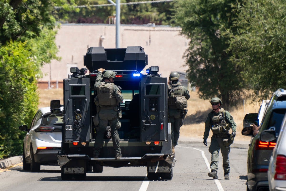 Police officers leave Zion Court after fugitive Eric Abril was captured on Monday (AP)