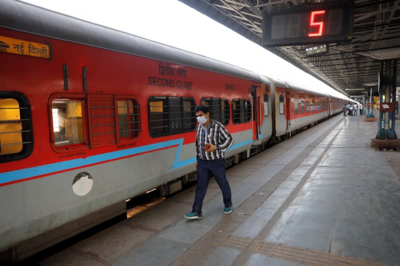 A man walks past a train at an almost empty platform during lockdown by the authorities to limit the spreading of coronavirus disease (COVID-19), in New Delhi