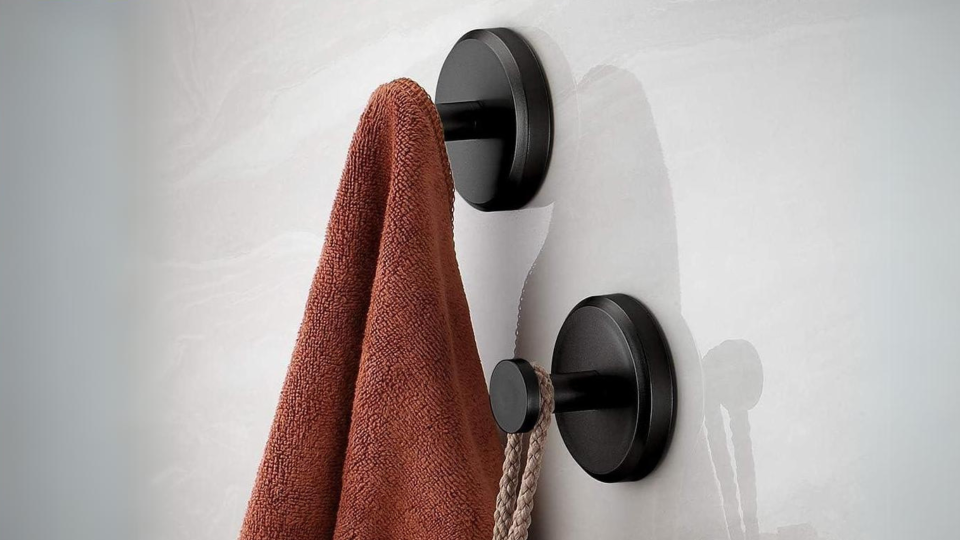 Bathroom hooks holding a towel and a loofah