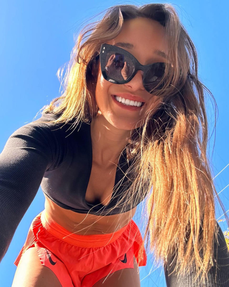 Kayla Itsines in a black crop top and red shorts