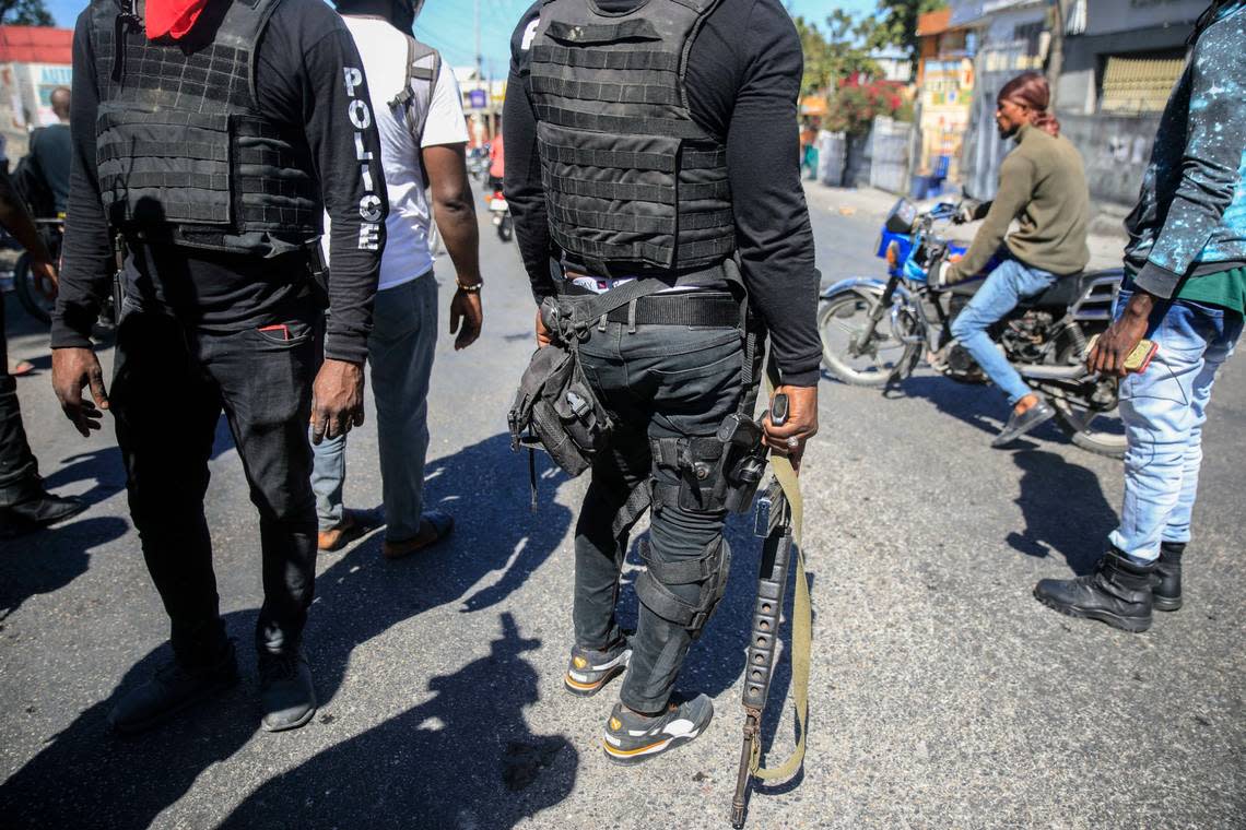 Armed police officer stands with his weapons drawn during a protest to denounce bad police governance, in Port-au-Prince, Haiti, Thursday, Jan. 26, 2023.