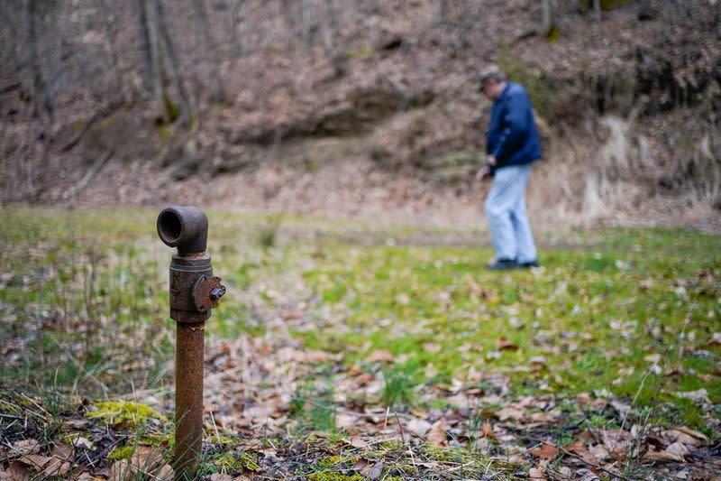 Hanson Rowe, a landowner who blames a leaky gas well for health problems, walks past the sight of a capped well on his property in Salyersville