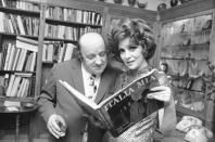 ARCHIVO - El escultor italiano Giacomo Manzu mira el libro "Italia Mia" que sostiene Gina Lollobrigida en su villa en Roma el 1 de diciembre de 1972 durante la presentación del libro de fotografías de la estrella italiana que le llevó dos años completar y editar. Lollobrigida murió en Roma a los 95 años el lunes 16 de enero de 2023, dijo su agente. (Foto AP/Giulio Broglio, archivo)