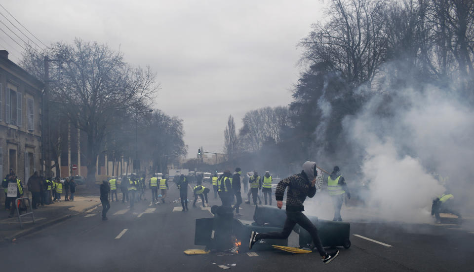 Yellow vest protestors set up barricades during a demonstration in Bourges, central France, Saturday, Jan. 12, 2019. Paris brought in armored vehicles and the central French city of Bourges shuttered shops to brace for new yellow vest protests. The movement is seeking new arenas and new momentum for its weekly demonstrations. Authorities deployed 80,000 security forces nationwide for a ninth straight weekend of anti-government protests. (AP Photo/Rafael Yaghobzadeh)