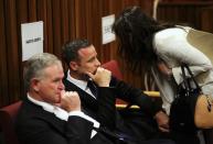 Barry Roux (L) sits with his client Olympic and Paralympic track star Oscar Pistorius at the end of the trial for the murder of his girlfriend Reeva Steenkamp, at the North Gauteng High Court in Pretoria, March 17, 2014. Pistorius is on trial for murdering his girlfriend Reeva Steenkamp at his suburban Pretoria home on Valentine's Day last year. He says he mistook her for an intruder. REUTERS/Siphiwe Sibeko (SOUTH AFRICA - Tags: CRIME LAW SPORT ATHLETICS)