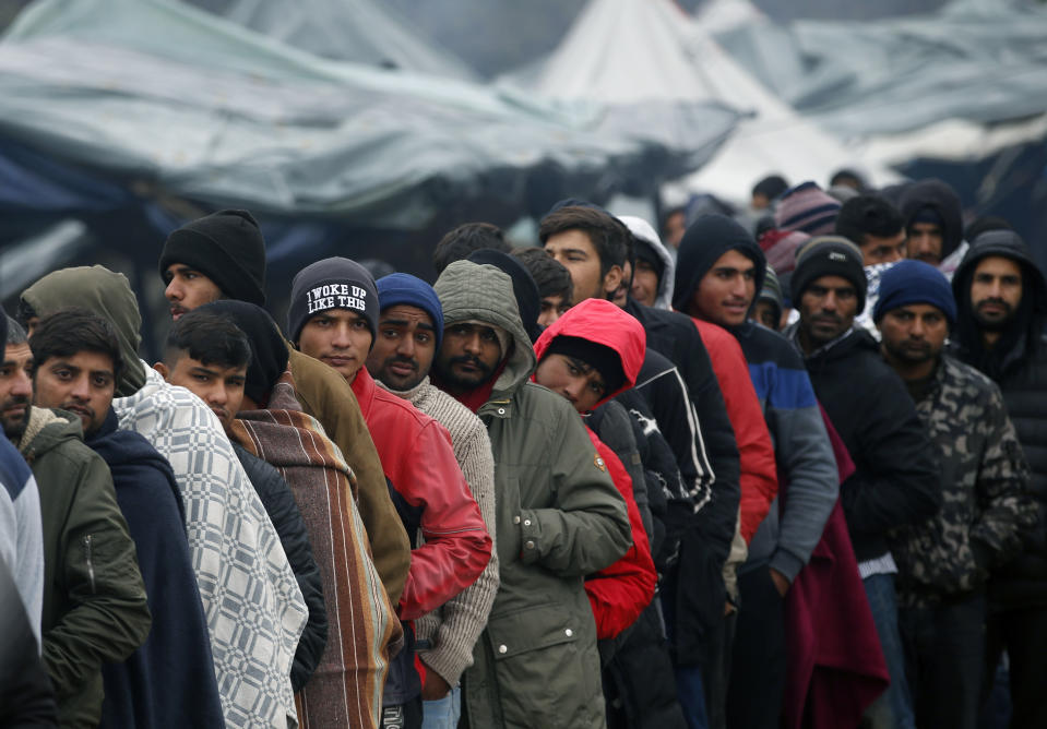Migrants wait in line to receive supplies from the Red Cross at the Vucjak refugee camp outside Bihac, northwestern Bosnia, Thursday, Nov. 14, 2019. The European Union's top migration official is warning Bosnian authorities of a likely humanitarian crisis this winter due to appalling conditions in overcrowded migrant camps in the country. (AP Photo/Darko Vojinovic)