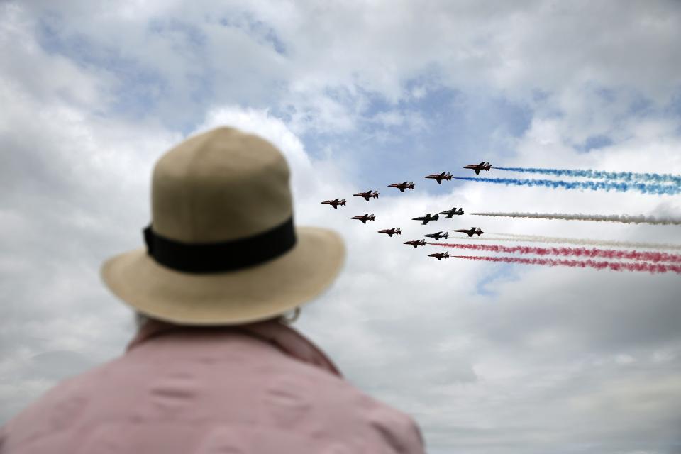 An aviation enthusiast watches The Royal Air Force aerobatic team, the Red Arrows, perform during The Royal International Air Tattoo at the RAF in Fairford