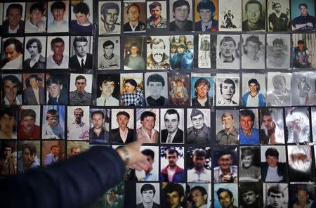 Hajra Catic points at the picture of her husband that is among pictures of victims of the genocide in Tuzla, December 23, 2014. REUTERS/Dado Ruvic